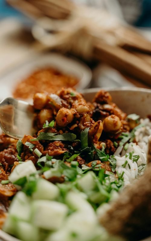 A close-up view of a vegan chickpea chili bowl with fresh cucumbers and herbs. Perfect for healthy eating enthusiasts.